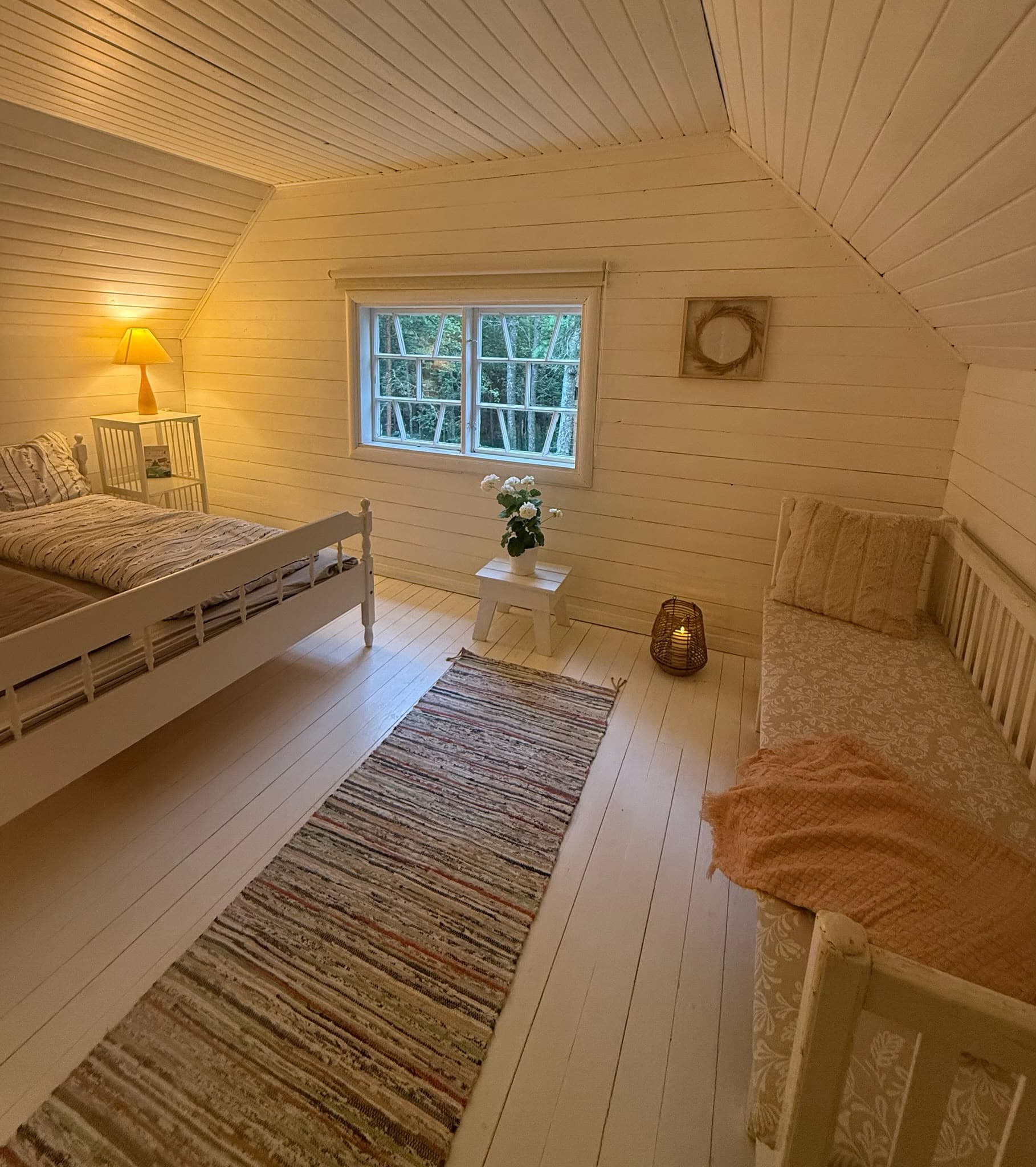 Helles Gästezimmer mit zwei Betten und Blick in den Wald